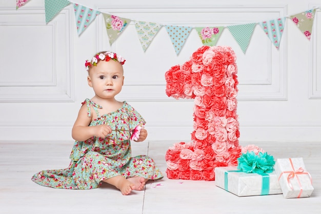 Little happy toddler girl celebrating first birthday.