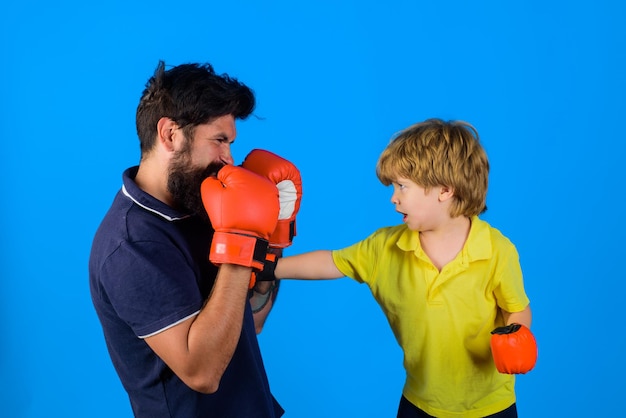 Little kid boxing dad and his son in boxing gloves child and instructor training in boxing ring