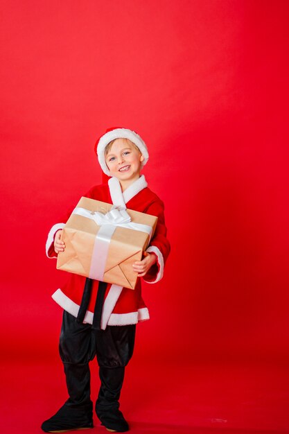 Photo little kid boy dressed as santa claus. christmas shopping. christmas present. childhood.