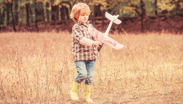 Little kid dreams of being a pilot Child playing with toy airplane Happy child playing Happy child playing outdoors Happy boy play airplane