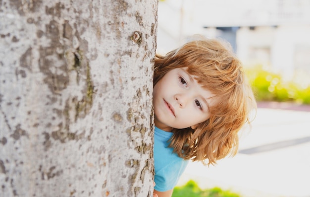 Little kid hide by tree Hide and seek Peekaboo