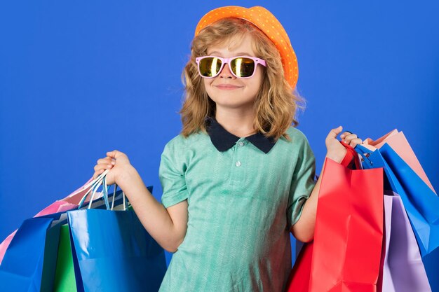 Little kid shopper Kid boy in fashion clothes on shopping Child with shopping packages Shopper child with shopping bag posing shopping bags on studio background