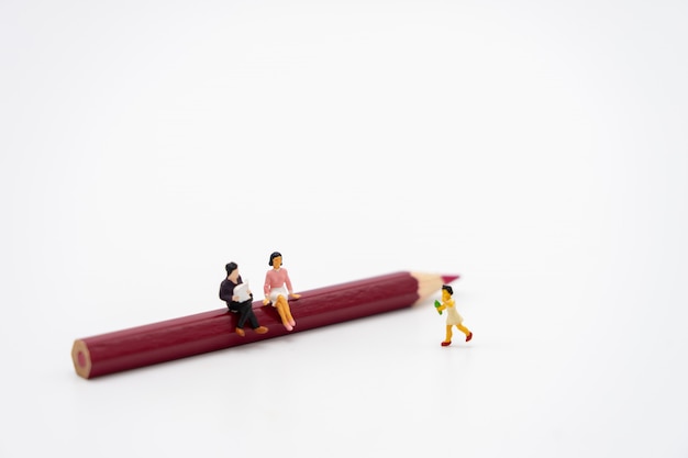 Little kids Miniature people sitting on books 