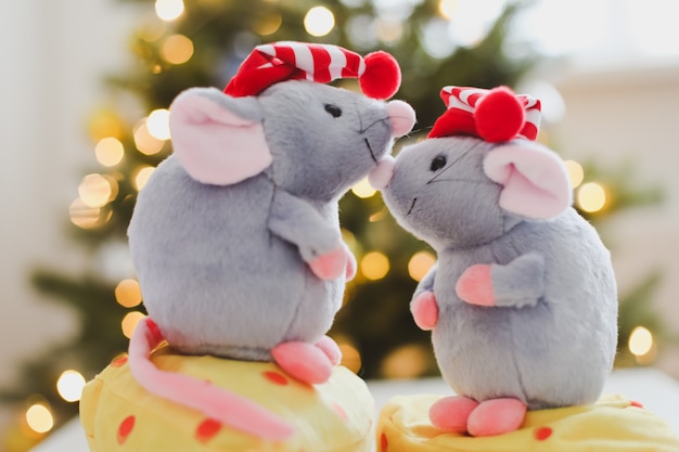 Little mouse toy and new year decorations by bokeh lights of a Christmas tree