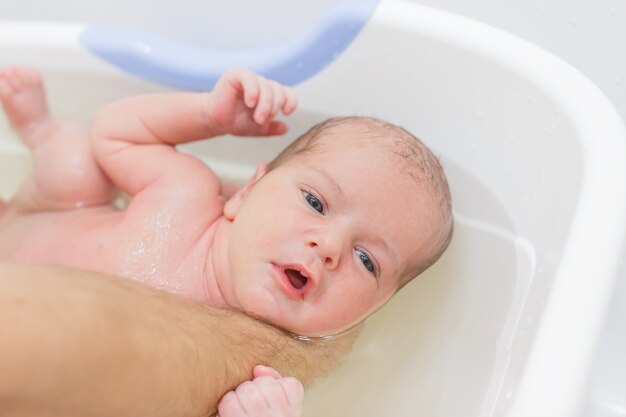 Little newborn baby having a bath