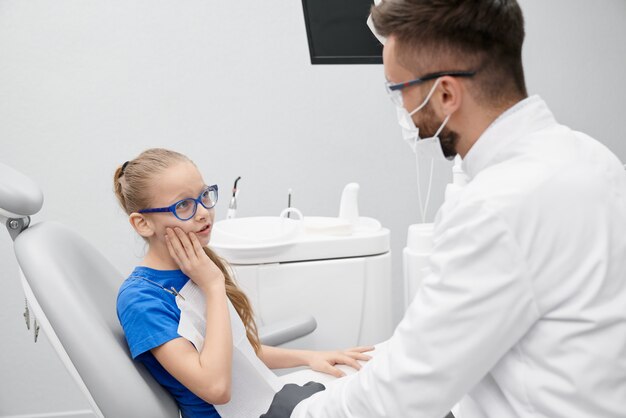 Little patient complaining about pain in teeth in clinic