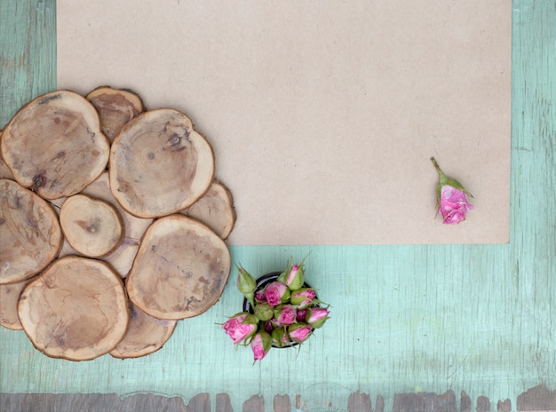 Little pink roses on old woden and craft paper surface