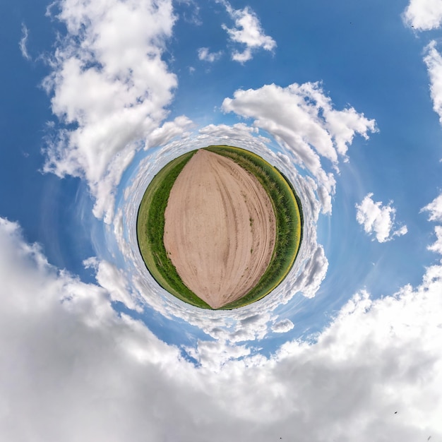 Little planet transformation of spherical panorama 360 degrees Spherical abstract aerial view on gravel road among field with awesome beautiful clouds Curvature of space