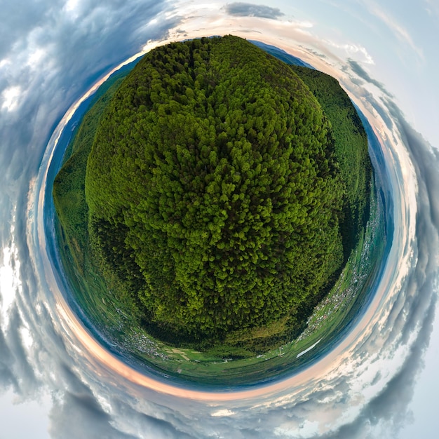 Little planet with dark mountain hills covered with green mixed pine and lush forest.