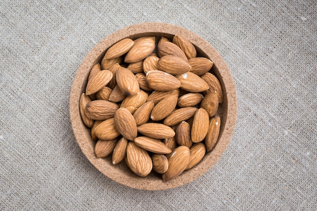 A little plate of almond nuts on a piece of canvas