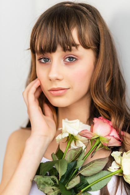 Little pretty girl in pink holds the bouquet of roses Close up the flowers and face little ballerina with a bouquet Beautiful small girl with fresh spring bouquet