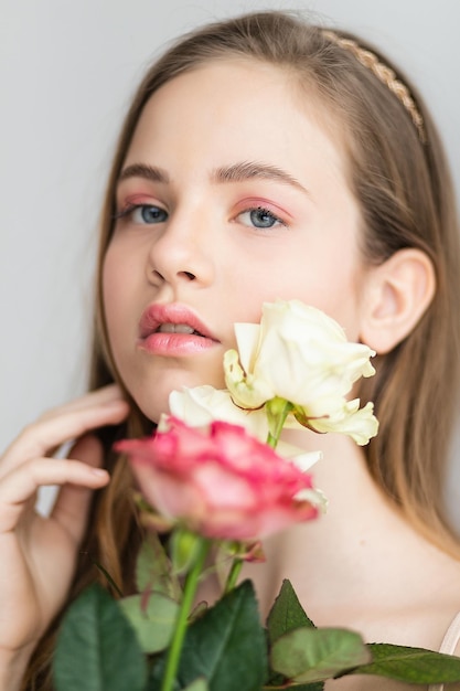 Little pretty girl in pink holds the bouquet of roses Close up the flowers and face