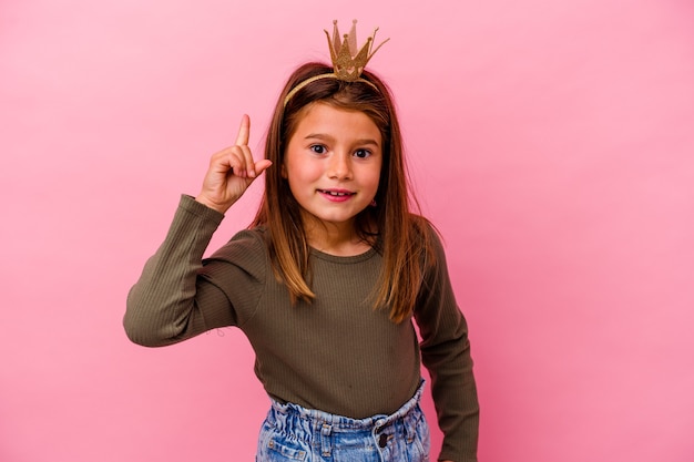 Little princess girl with crown isolated on pink having an idea