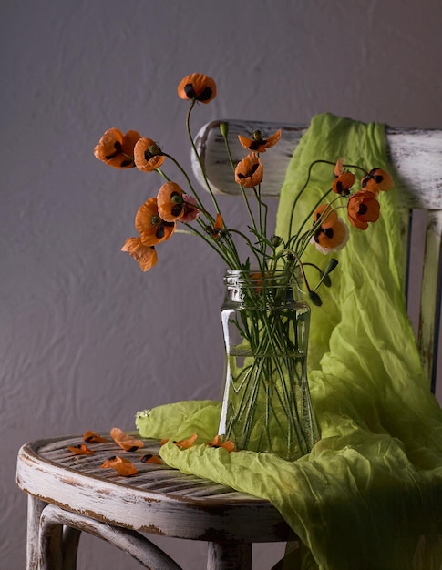 A Little Red Poppies Bouquet Arranged In Classical Style Stillife of popies in a glasses vase on vintage hair