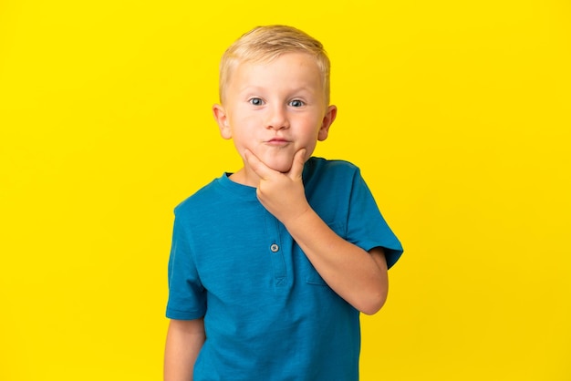 Little Russian boy isolated on yellow background happy and smiling