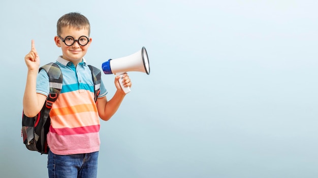 Little schoolboy with megaphone on blue background boy with megaphone