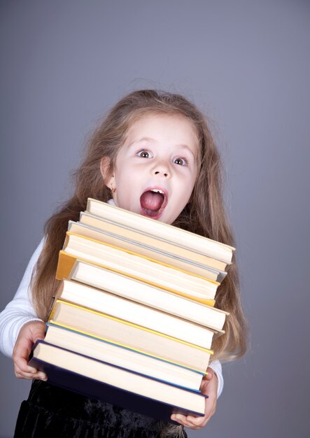 Little schoolgirl with books. 