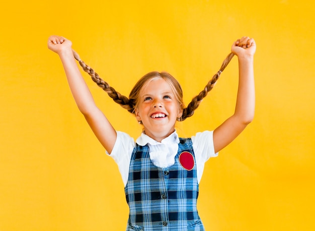 Little schoolgirl with a happy smile. Little schoolgirl in school uniform. 
