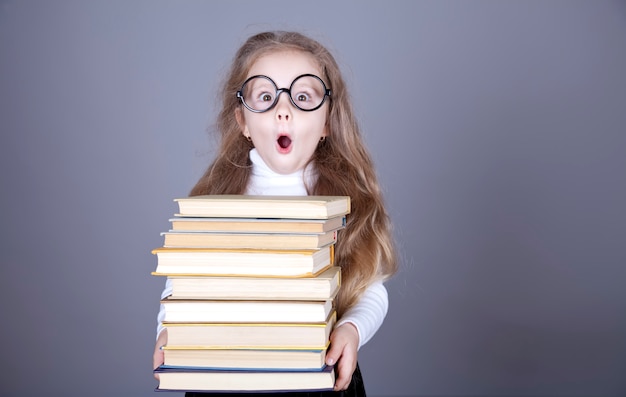 Little schoolgirl witn books. 