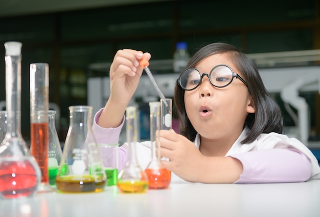 little scientist in lab coat making experiment 