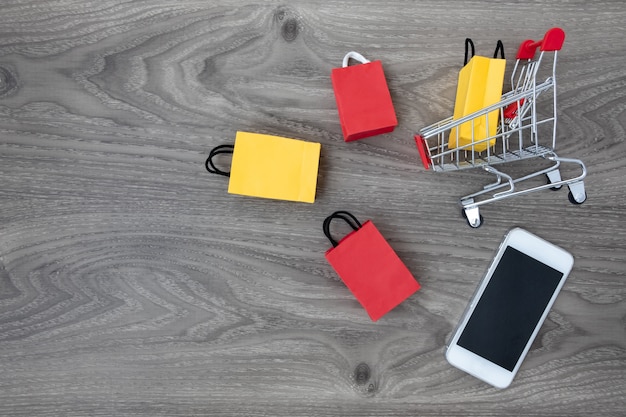 little shopping bags and cart on wood