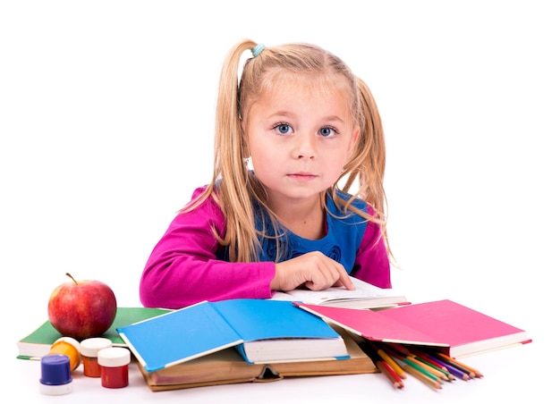 Little smart girl holding a book and reading it on a white background