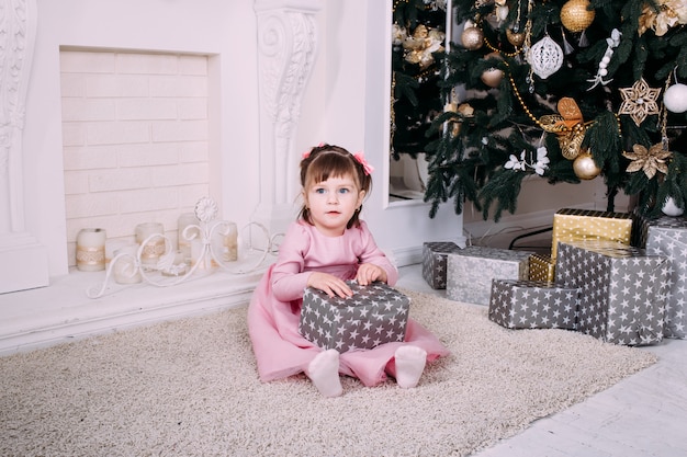 Little smiling girl with christmas gift box