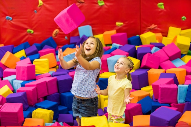 Little smiling girls playing in the amusement park