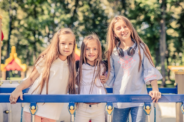 Little smiling girls stand hugging together