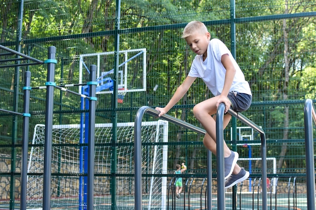 Little sportsman on the horizontal bar on playground. children's sports for health