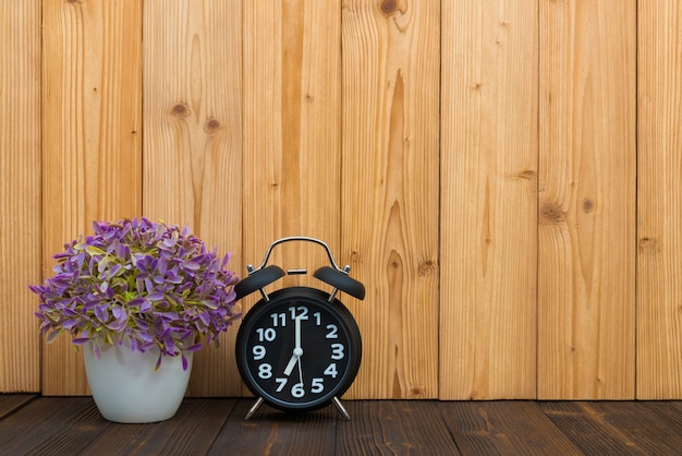 Little tree  with vintage alarm clock on wood