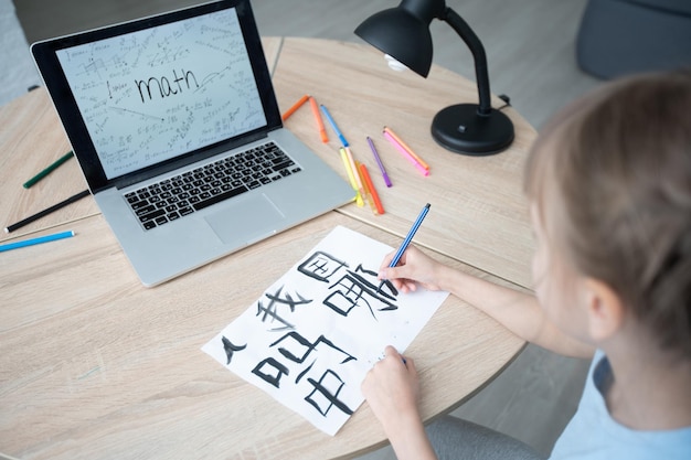 A little white girl in the lesson of chinese calligraphy. little girl learning chinese