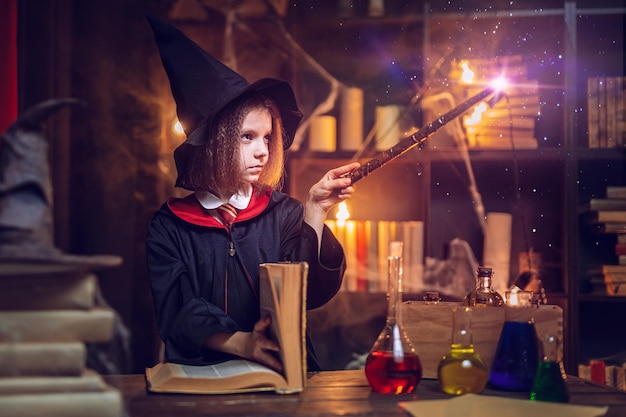 Little witch makes a spell with a magic wand Halloween party Cosplay Happy childhood