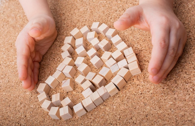 Little wooden cubes form heart shape or valentines day symbol