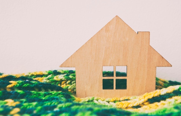 The little wooden house wrapped in the scarf lying on the radiator in the house