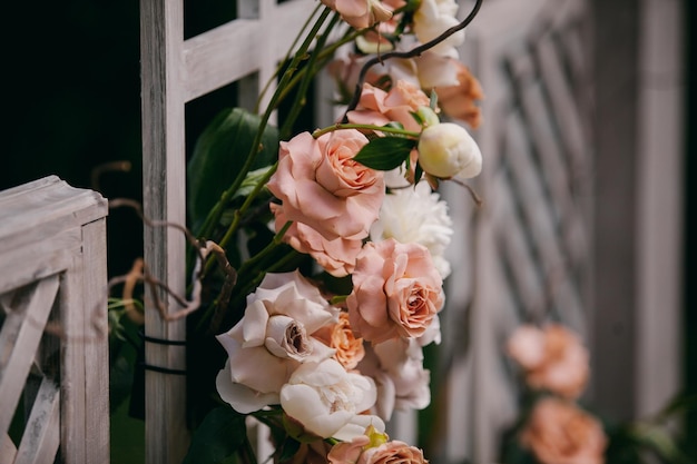 live red and white roses - decoration of a wooden wedding arch in the garden.