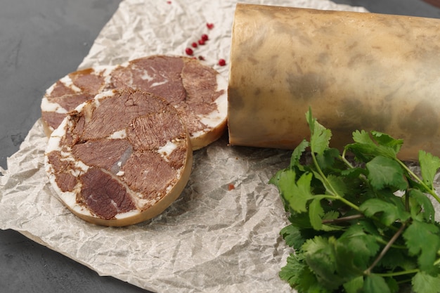 Liver sausage on parchment with parsley on gray