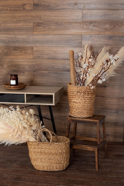 Living room hygge cozy home decor with wicker baskets with dry pampas grass and flowers