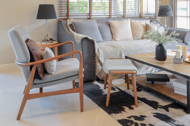 Living room interior with pillows on sofa and decorative wooden table with lamp