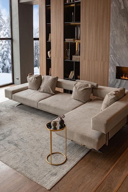 Living room marble wall fireplace and stylish bookcase in chic expensive interior of luxury country house with a modern design with wood and led light gray furniture with gold elements