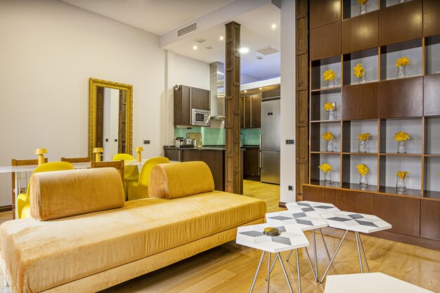 Living room of a vacation rental apartment with a sofa upholstered in yellow fabric and a multitude of decorative details of the same color