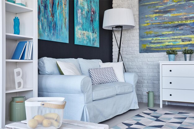 A living room with a blue sofa and a white shelf with a bookcase that says'a baby '