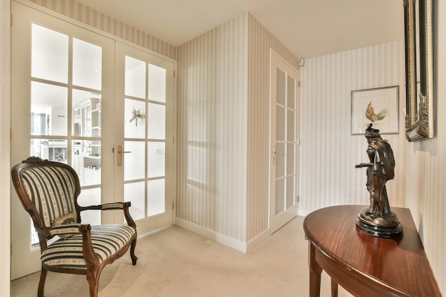 a living room with a chair and lamp on the table in front of an open door that leads to another room