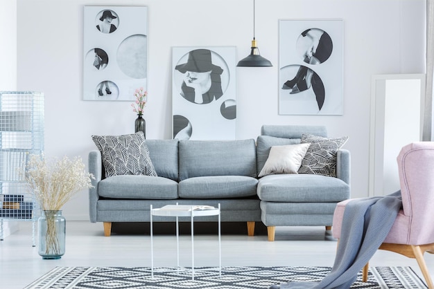 A living room with a sofa and a lamp on the wall.