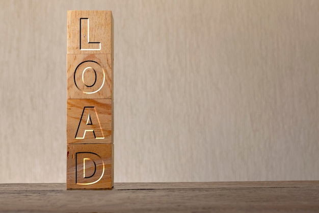 Load engraved on wooden cubes on a blurred background