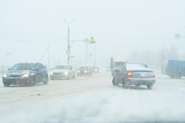 A loaded with traffic highway during massive snowfall, cars, pedestrian, road