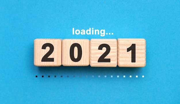 Loading 2021 years on wooden cubes on a blue background