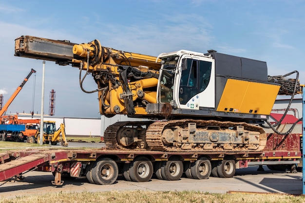 Loading of a drilling rig for the installation of bored piles onto a trawl for transportation to the place of work. Powerful construction machine. Pile foundations.