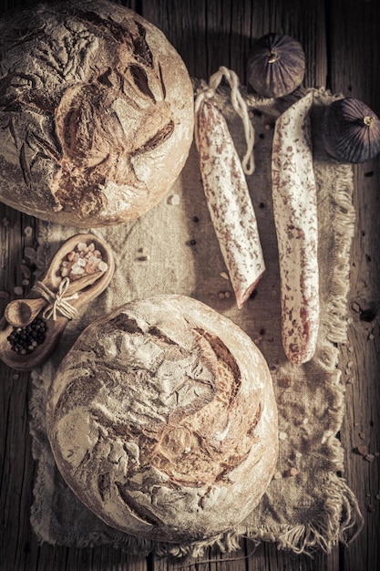 Loaf of bread with cheese and sausage on linen cloth