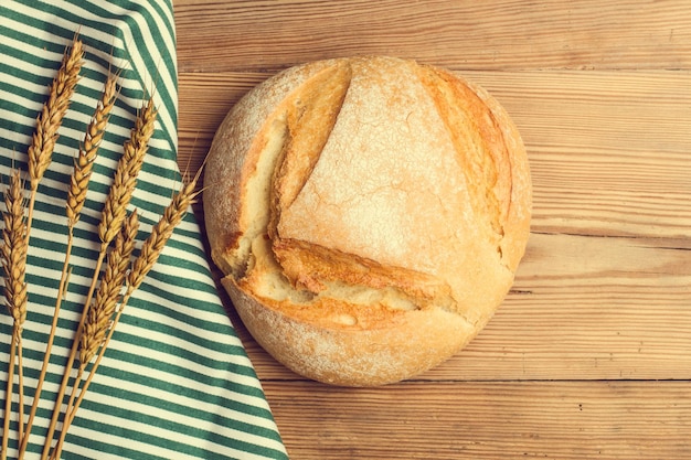 A loaf of bread on a wooden table in a top view